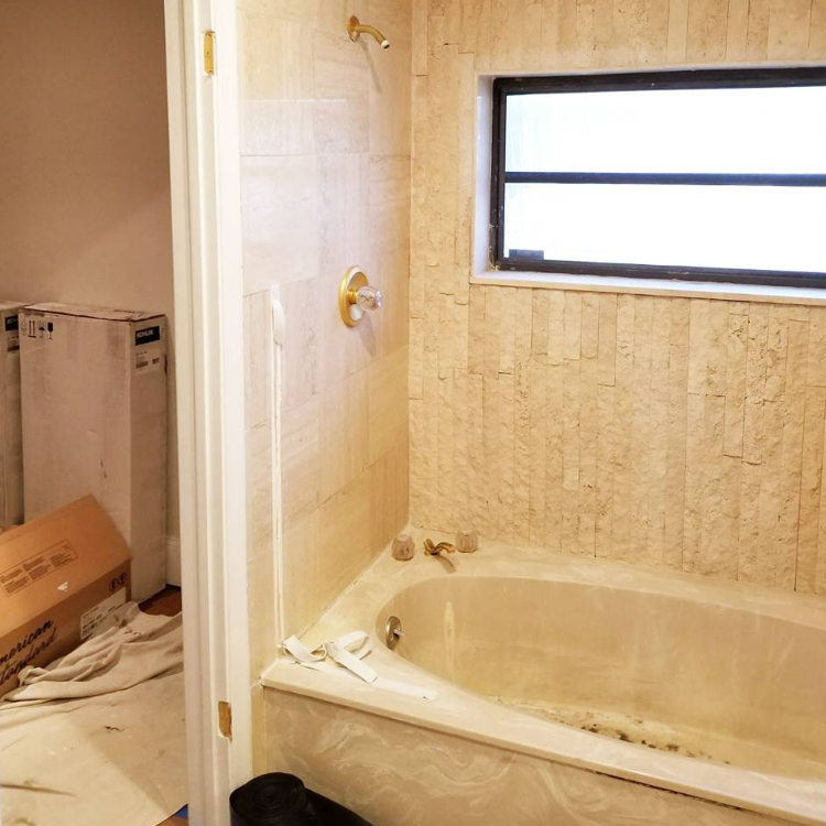 A bathroom with a bathtub and a window