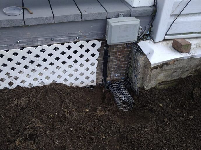 A box is sitting on the ground next to a brick wall.