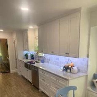 Kitchen with white cabinets, stainless steel sink, and countertops.