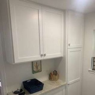 White cabinets with doors and shelves; a small countertop is visible.