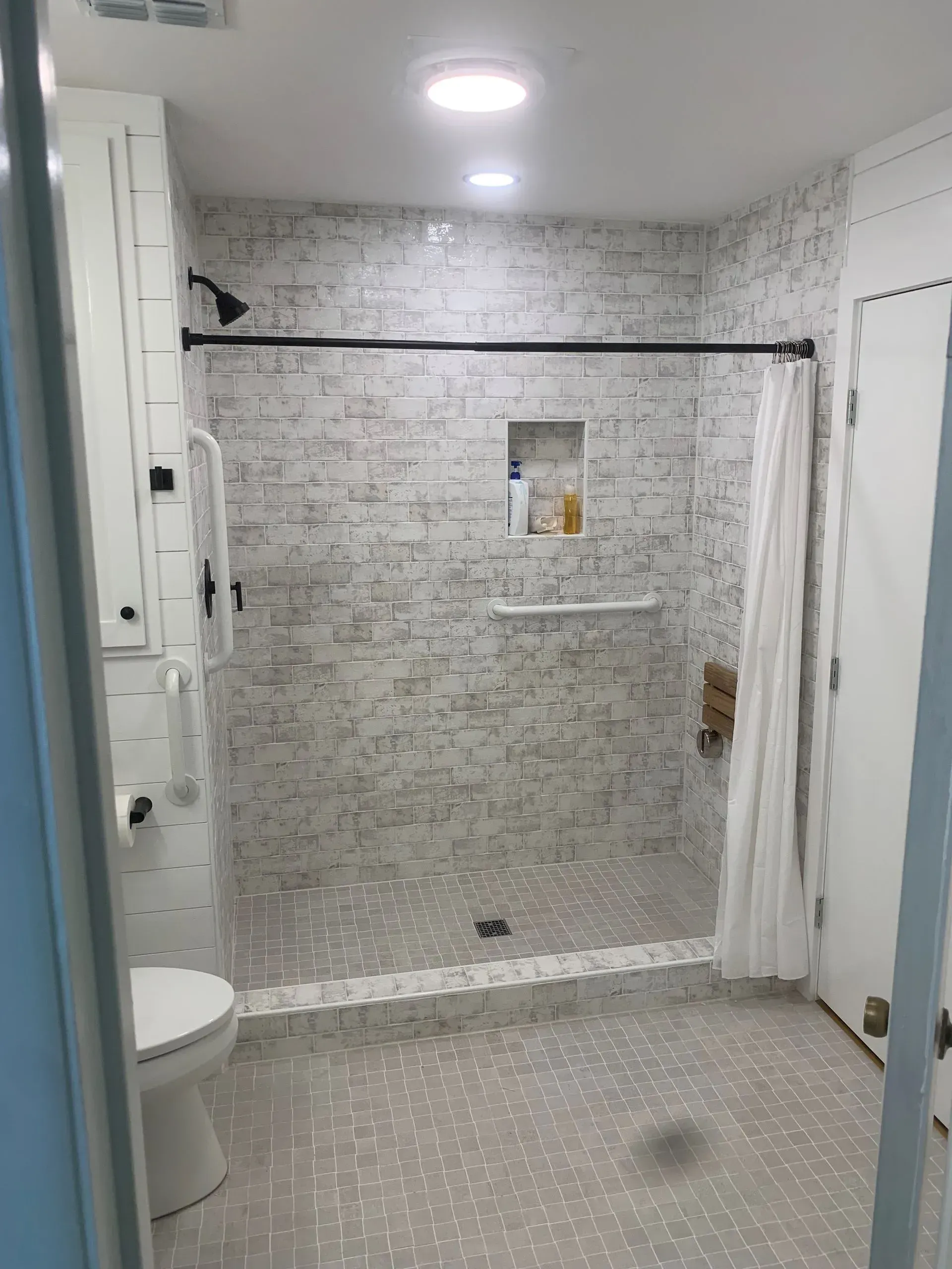 Bathroom with gray tiled shower and floor. 
