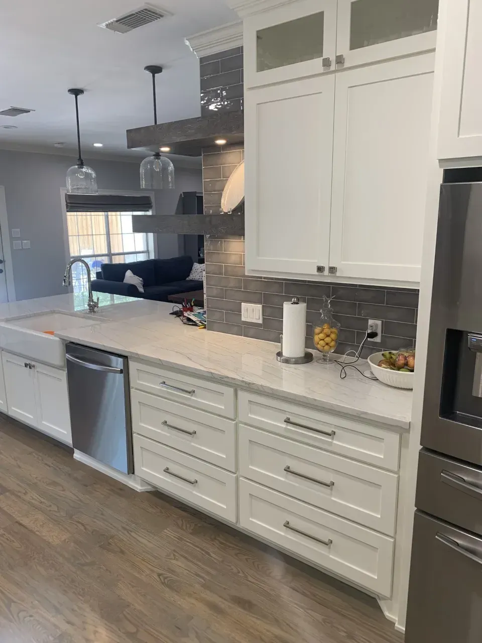 White kitchen cabinets and countertops with stainless steel appliances.