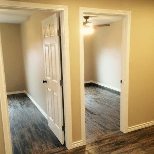Two doorways leading into rooms with wood floors and light-colored walls.