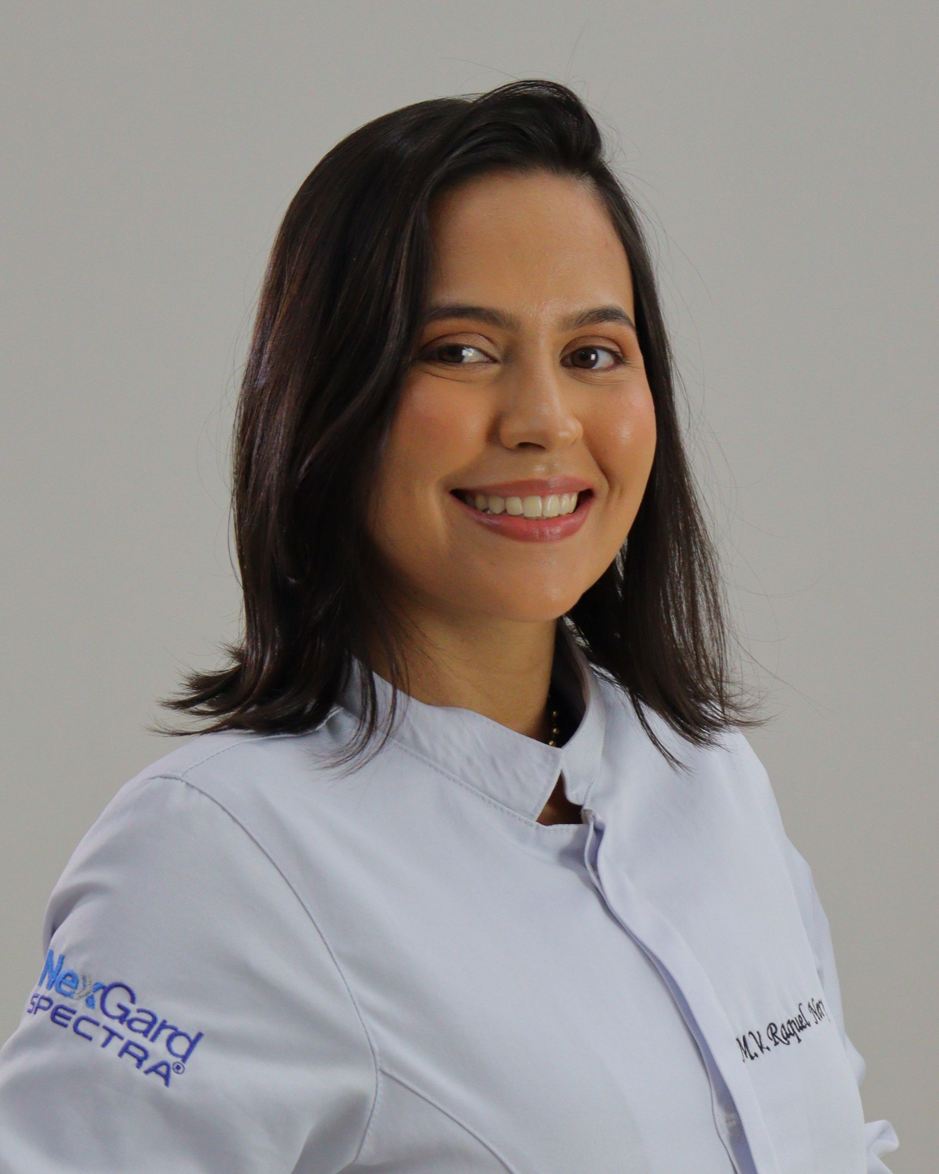 Homem de uniforme cirúrgico azul, com os braços cruzados, olhando para o lado.
