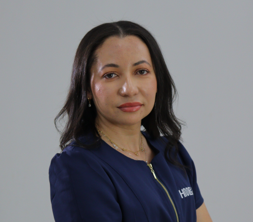 Veterinária de uniforme azul segurando um cachorrinho, sorrindo.