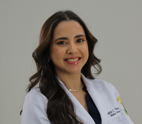 Mulher vestindo uniforme cirúrgico verde-azulado e estetoscópio, braços cruzados, sorrindo.