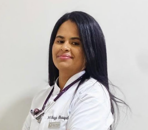 Homem de uniforme cirúrgico azul, com os braços cruzados, olhando para o lado.