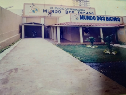 Clínica veterinária "Mundo dos Bichos" com uma longa passarela e um pequeno gramado.