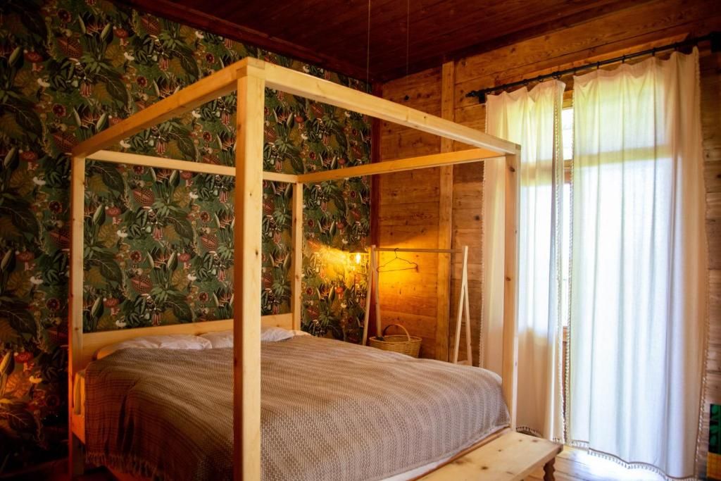 A bedroom with a four poster bed and a window.