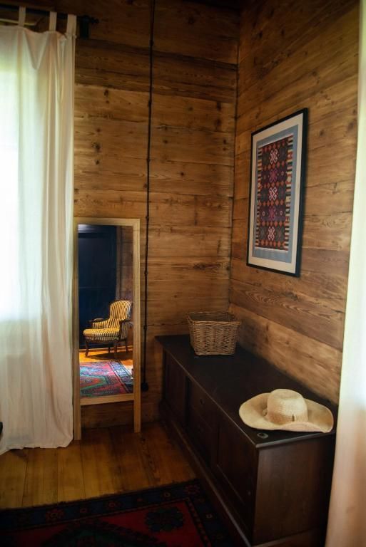 A room with a mirror and a hat on a dresser