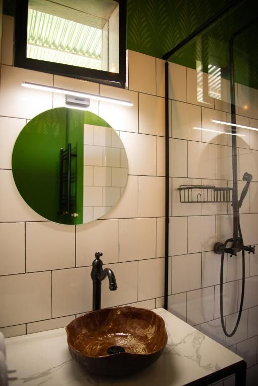 A bathroom with a sink , mirror and shower.