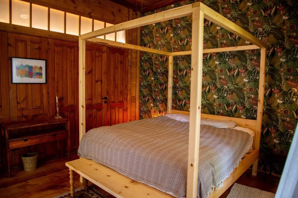 A bedroom with a four poster bed and a bench