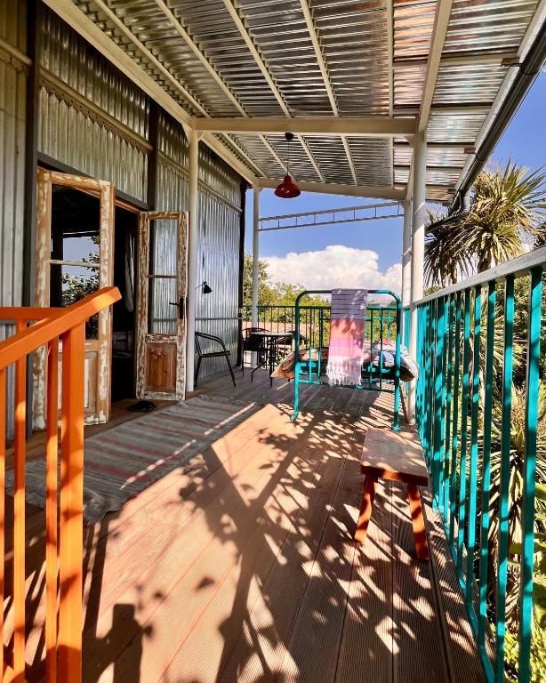 A porch with a blue railing and a bed on it