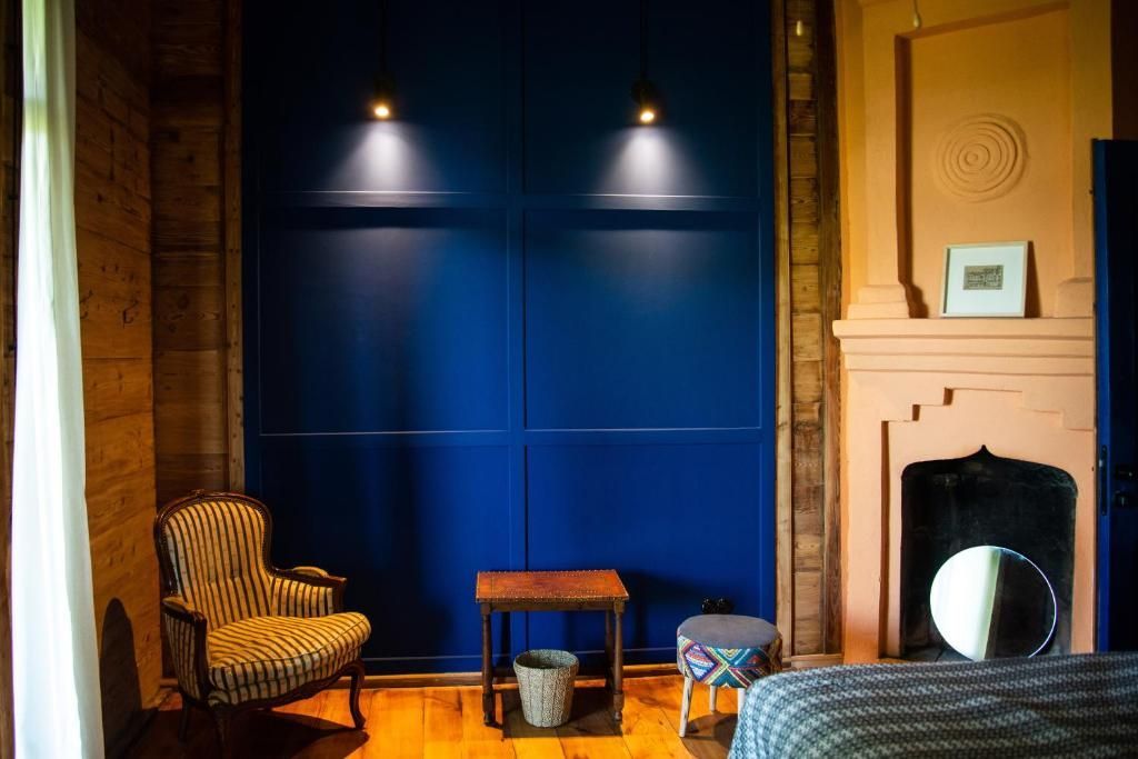 A bedroom with a bed , chair , table and fireplace.