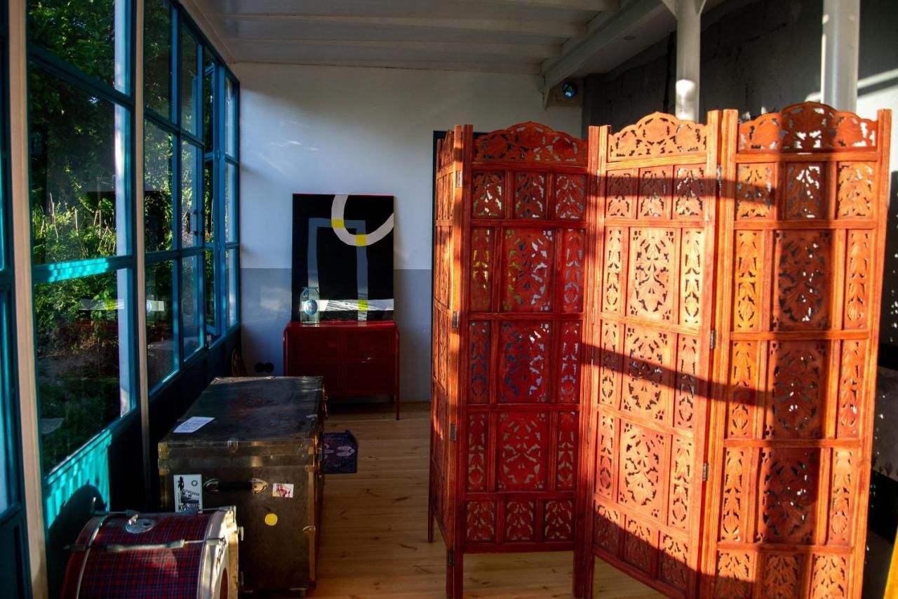 A room with a wooden room divider and lots of windows