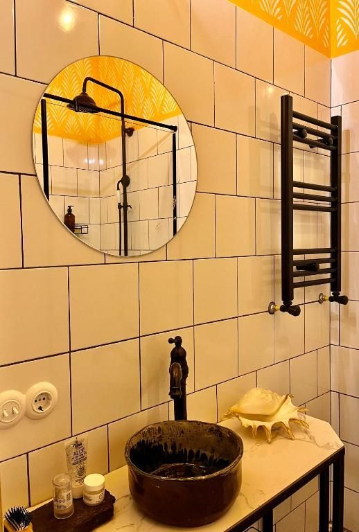 A bathroom with a sink , mirror and towel rack.