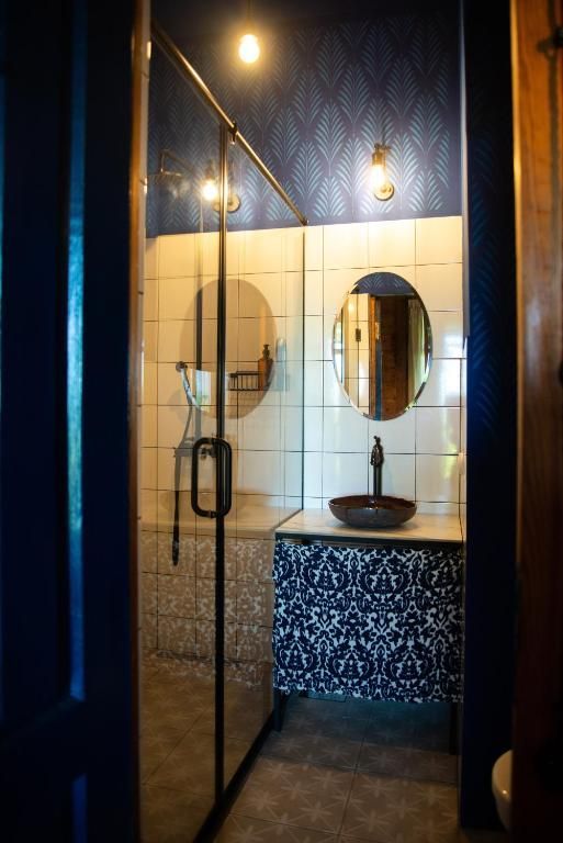 A bathroom with a sink a mirror and a walk in shower