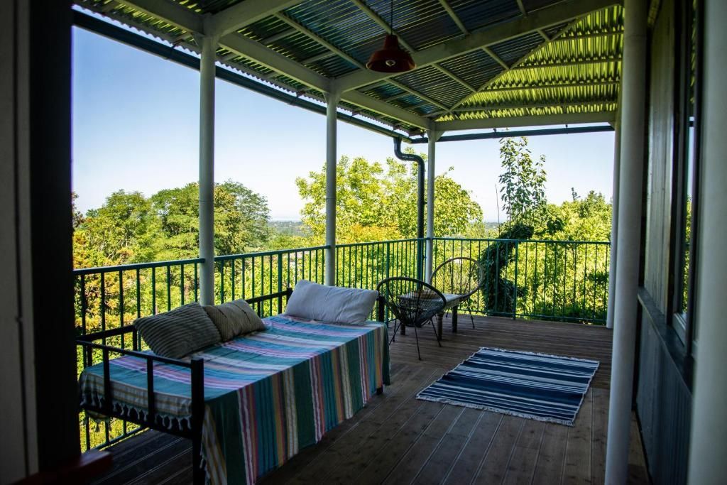 A porch with a bed and a rug on it