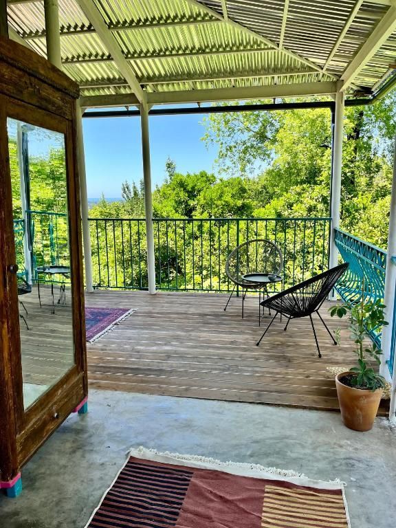A wooden deck with chairs , a table and a mirror.