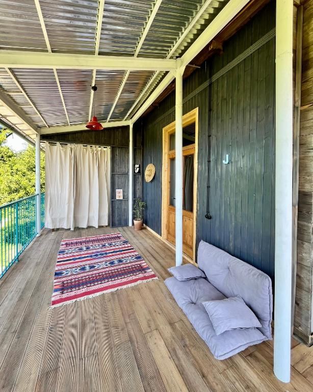 There is a couch on the porch of a house.