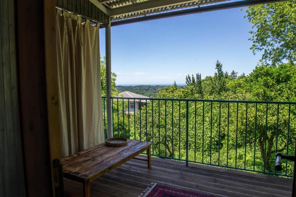 A balcony with a view of trees and a blue sky