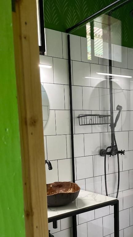 A bathroom with a sink , mirror and shower.