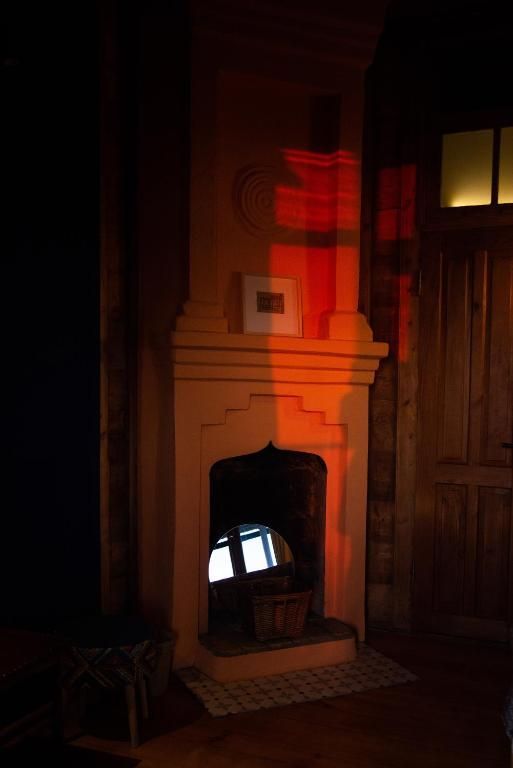 A fireplace is lit up in a dark room