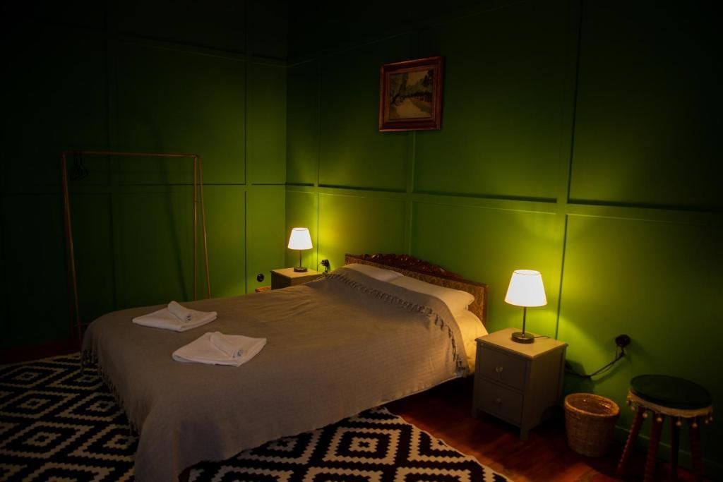 A bedroom with a bed , nightstands , lamps and a picture on the wall.