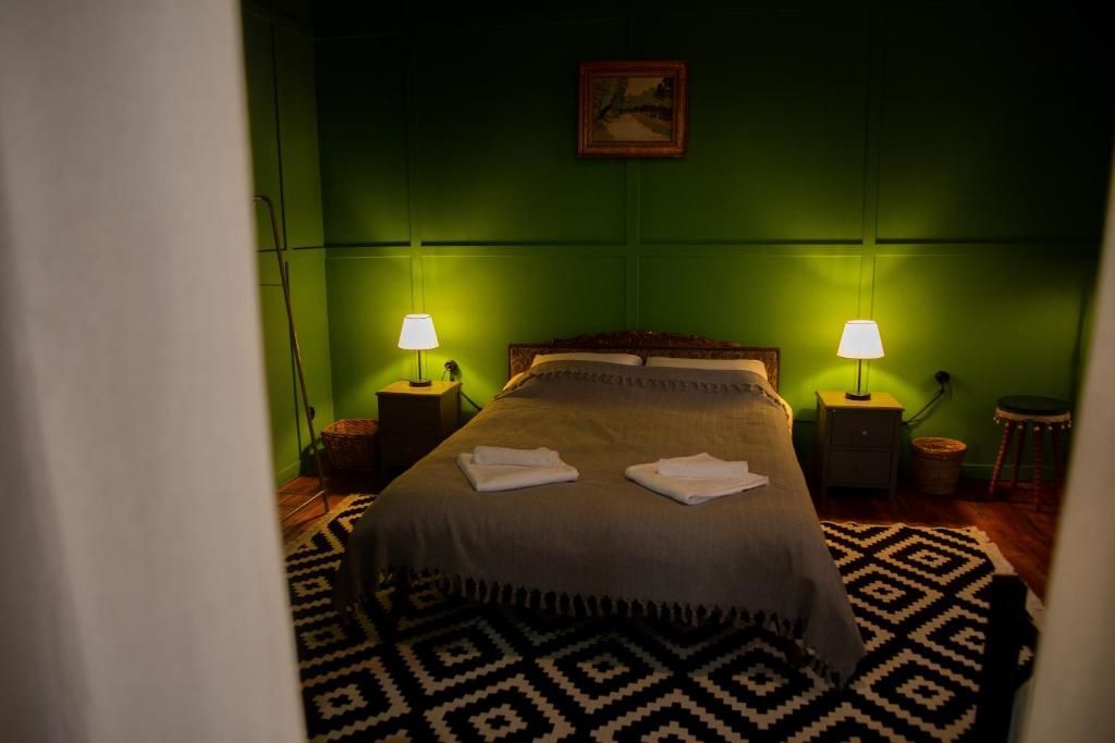 A bedroom with a bed , nightstands , lamps and a rug.