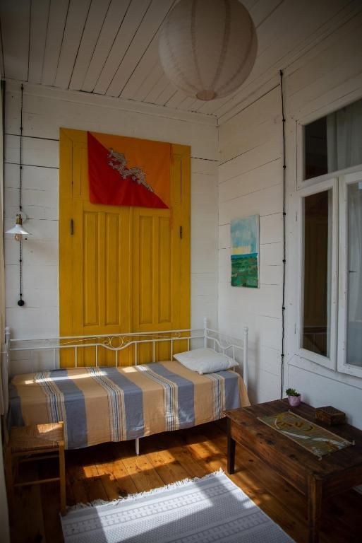 A bedroom with a bed and a yellow door