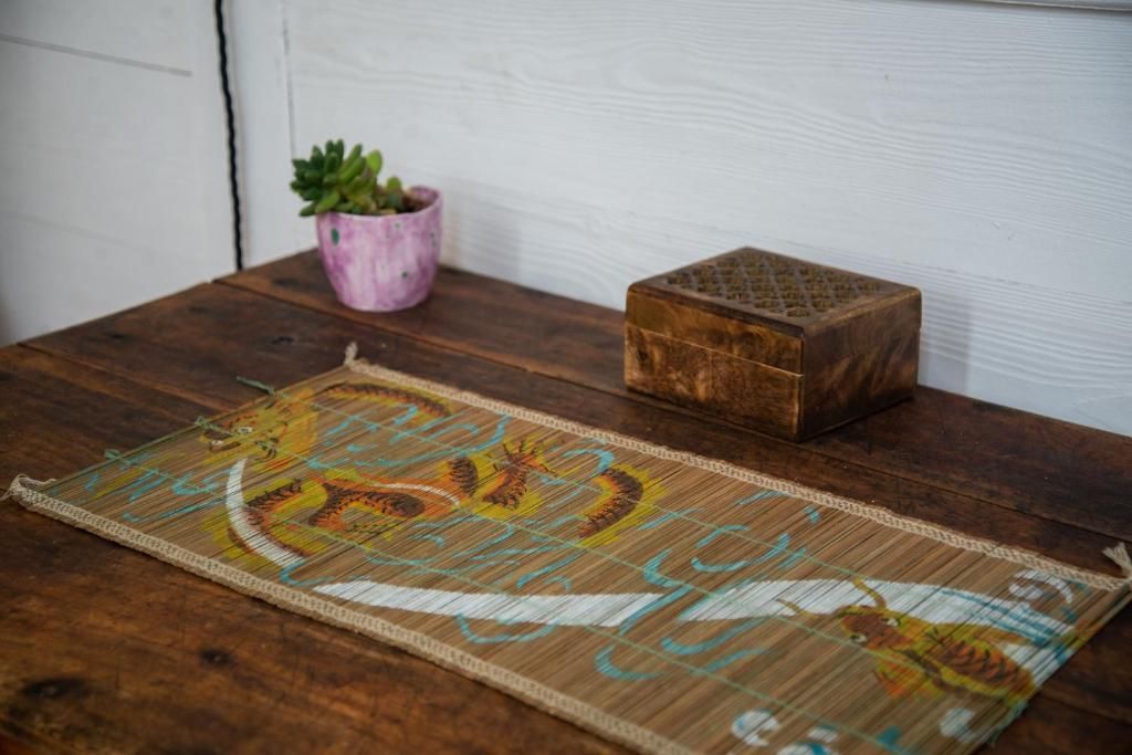 A table with a table runner and a potted plant on it.