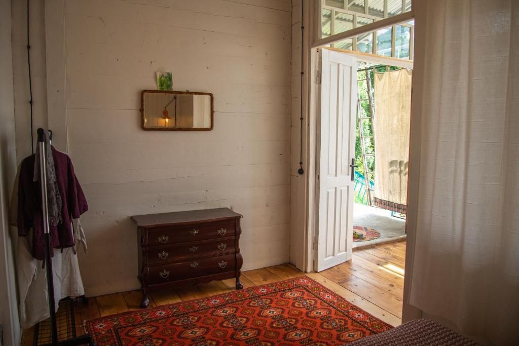 A bedroom with a bed , dresser , mirror and rug.