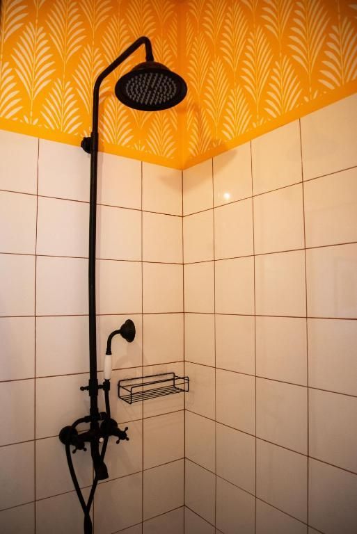 A shower with a yellow ceiling and white tiles