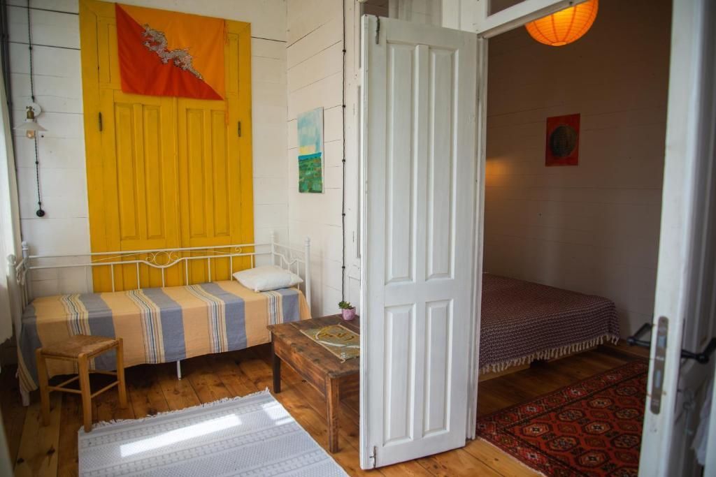 A bedroom with two beds , a table and a rug.