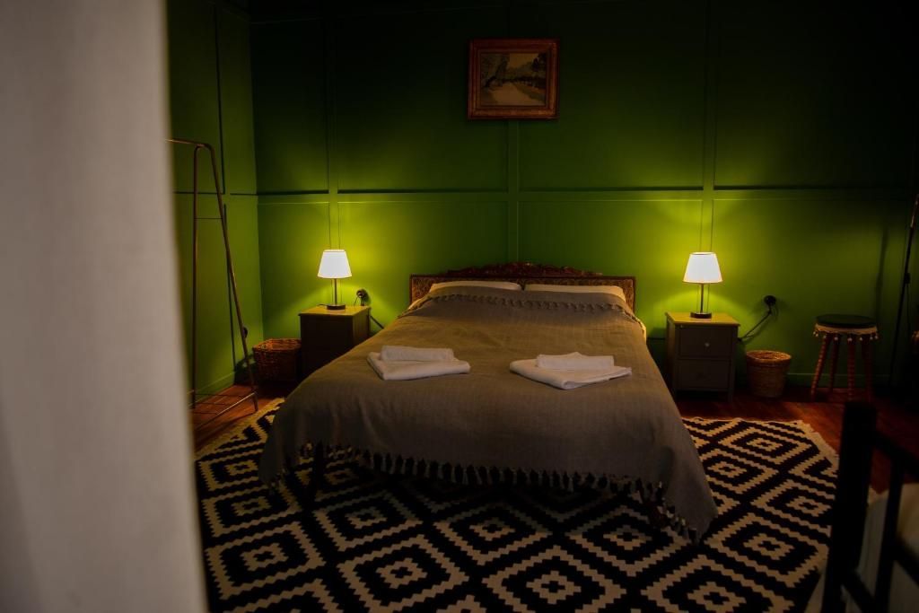 A bedroom with a bed , nightstands , lamps and a rug.