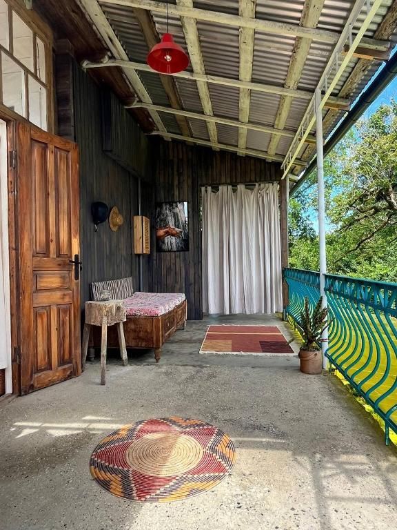 A porch with a couch and a rug on it.