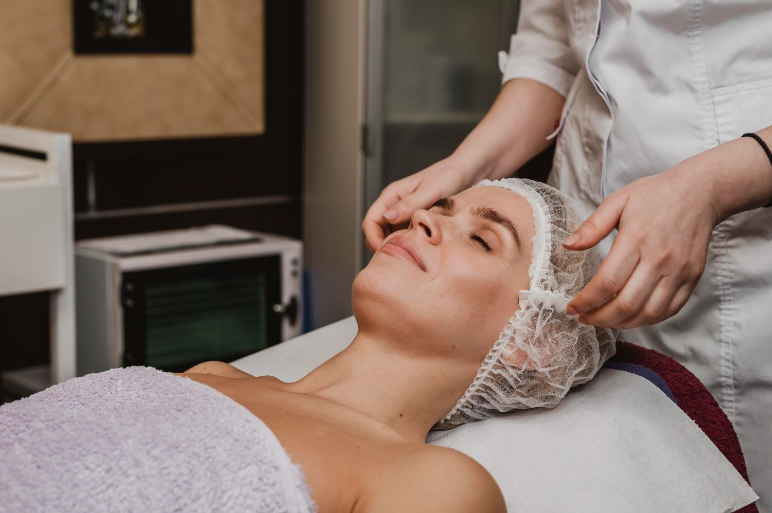 A woman is getting a facial treatment in a beauty salon.