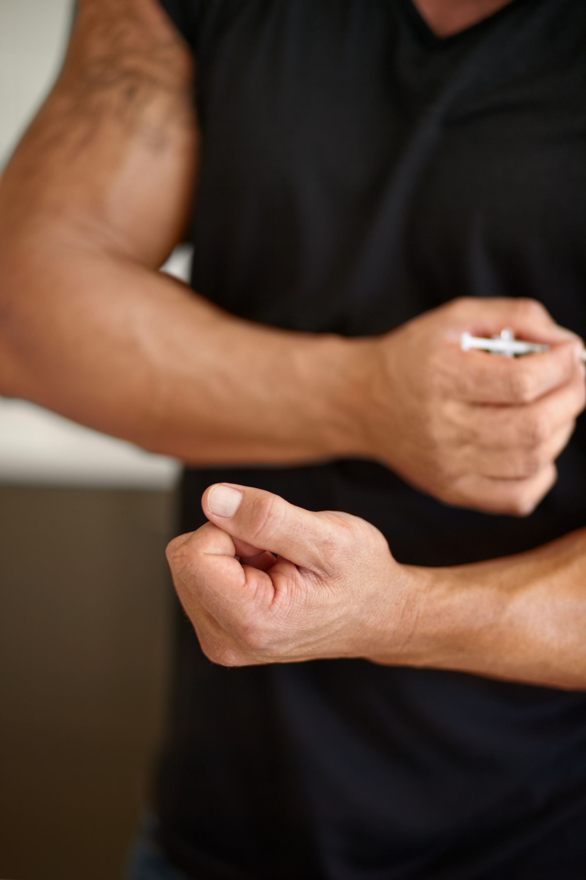 A man in a black shirt is holding something in his hands