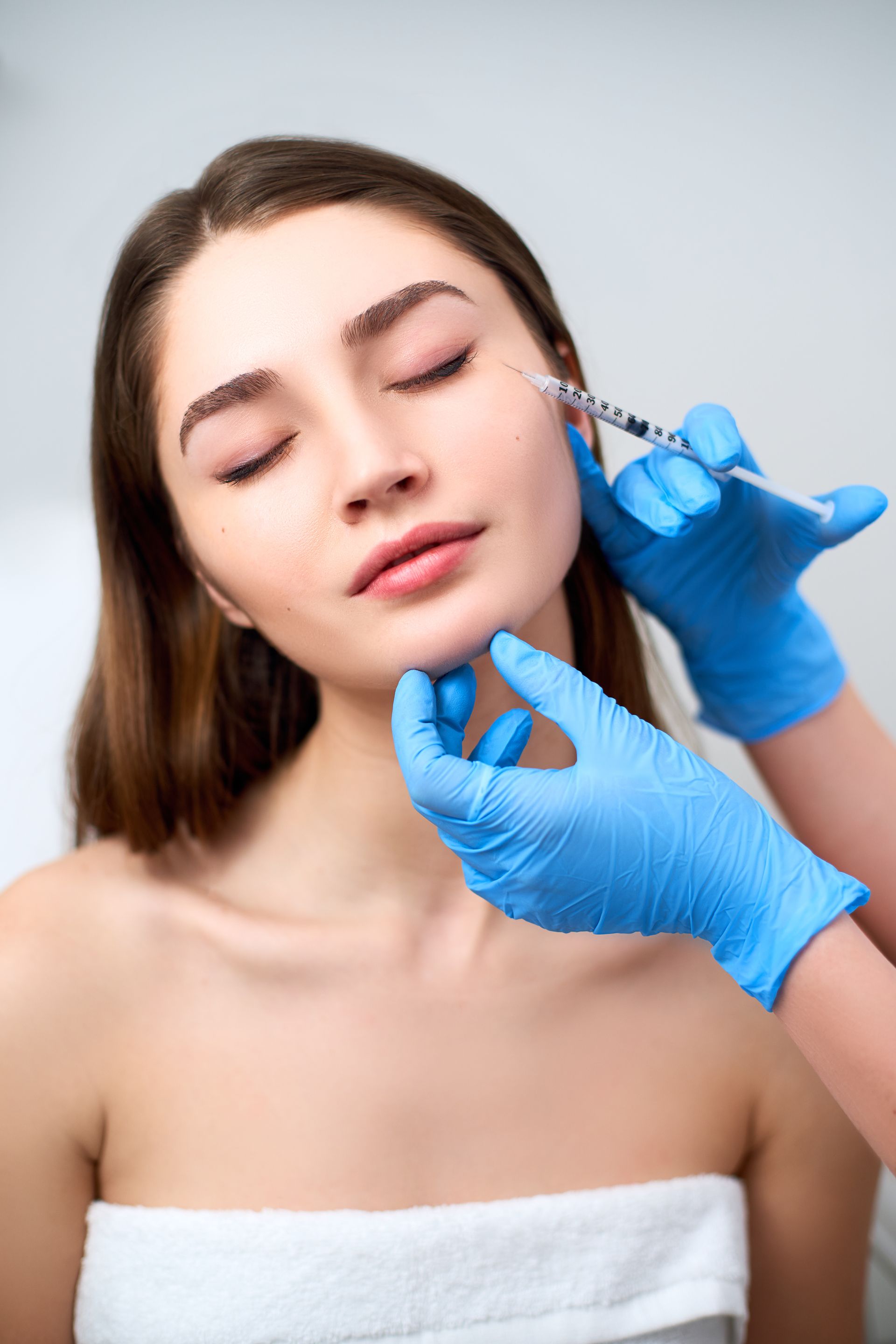 A woman is getting a botox injection in her face.