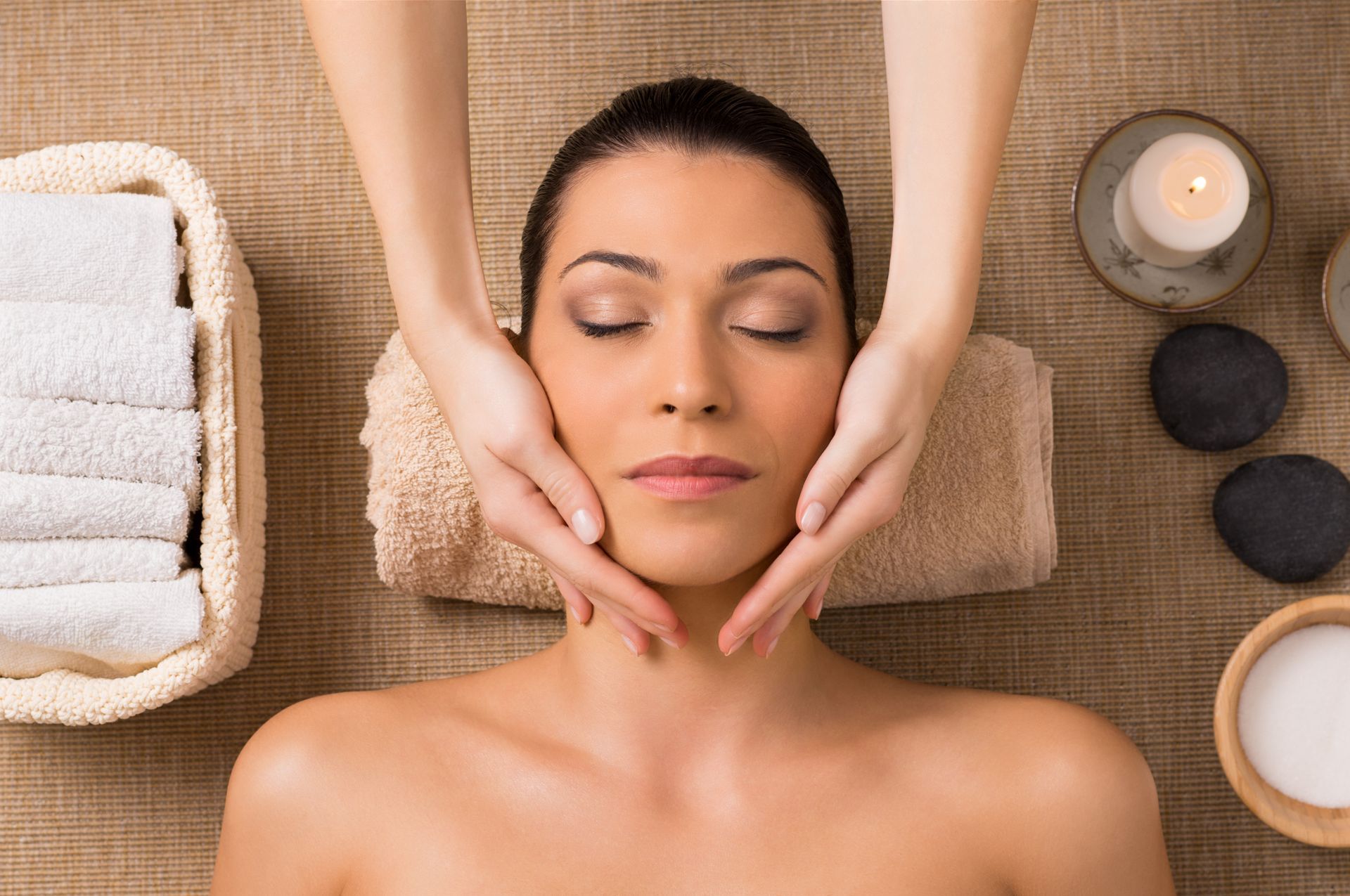 A woman is getting a facial massage at a spa.