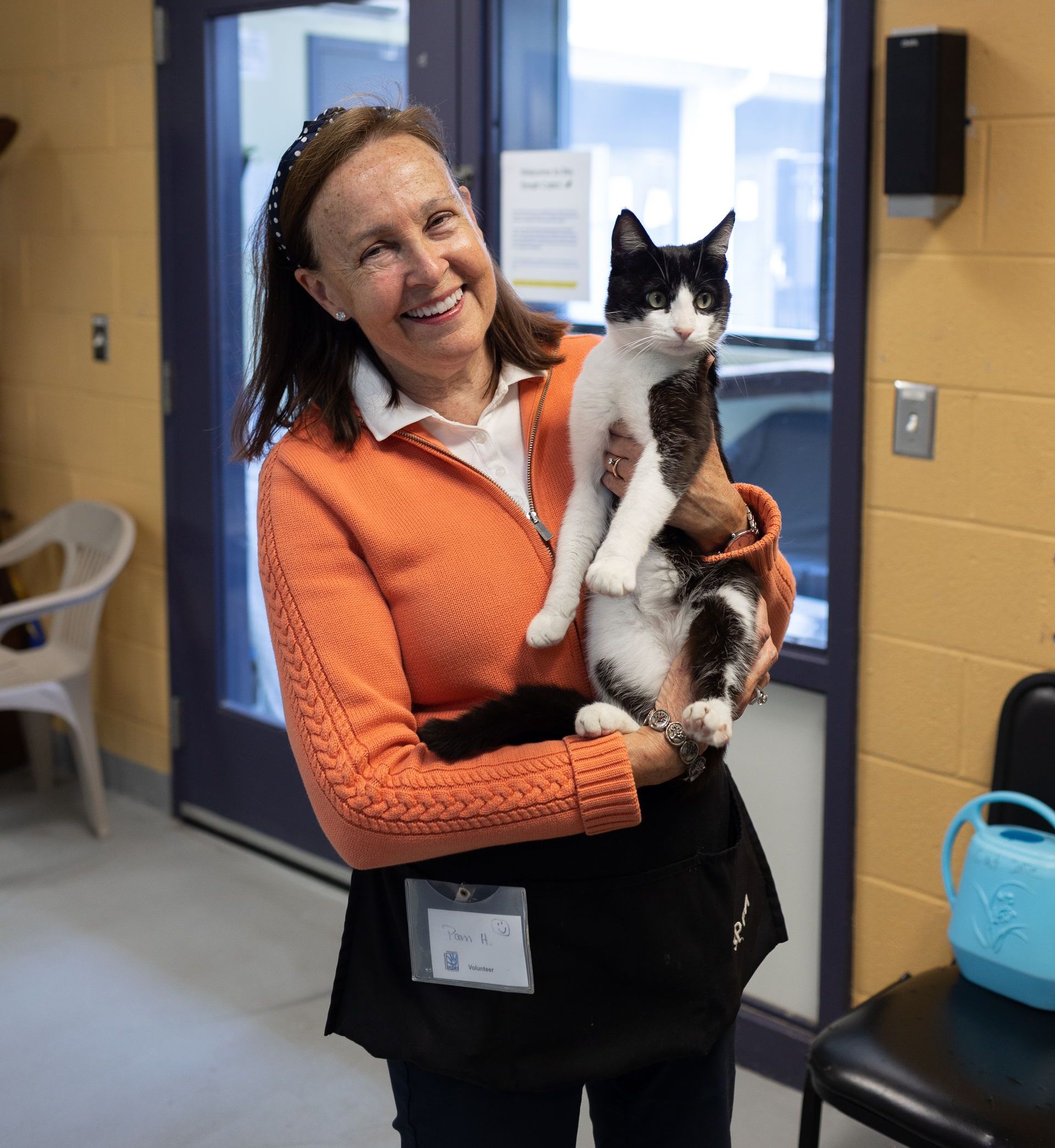 volunteer holding a black and white cat