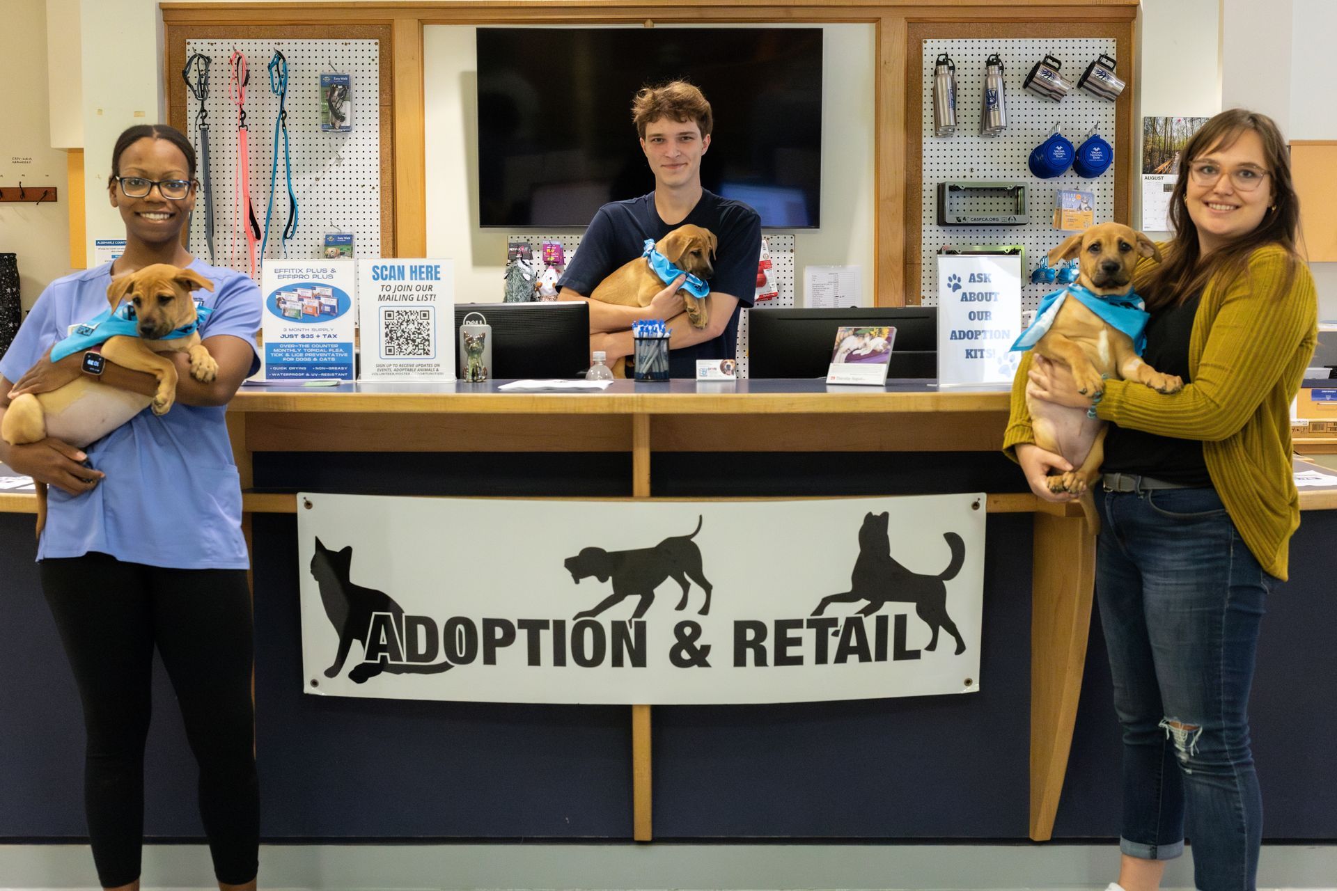 picture of CASPCA 3 staff holding pets in front desk