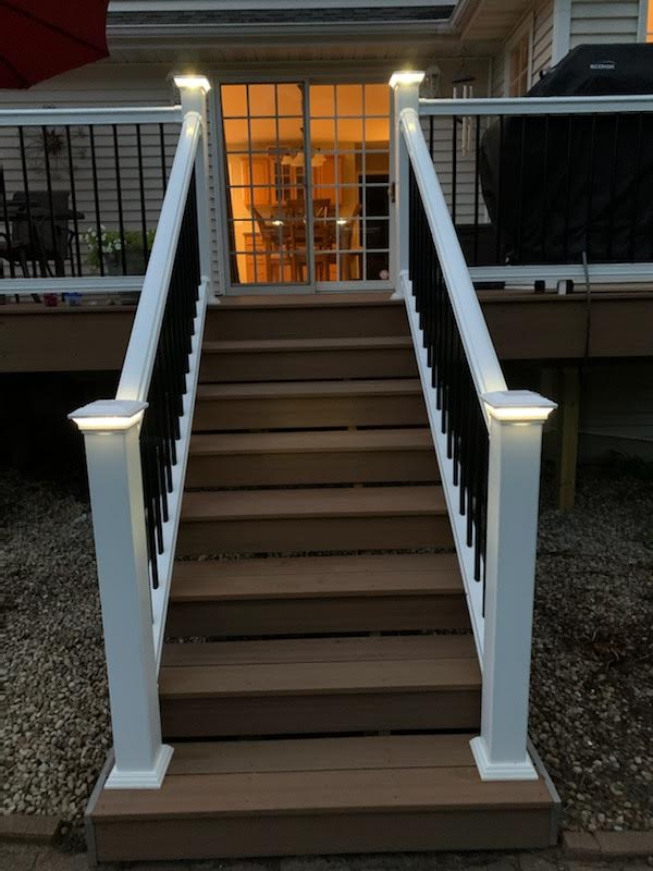 A set of stairs leading up to a deck with a white railing