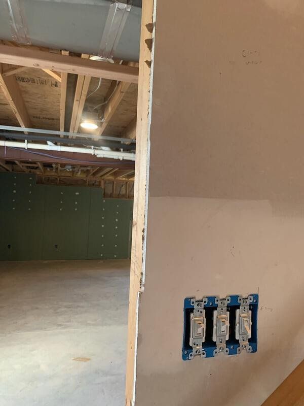 An empty room with a light switch on the wall