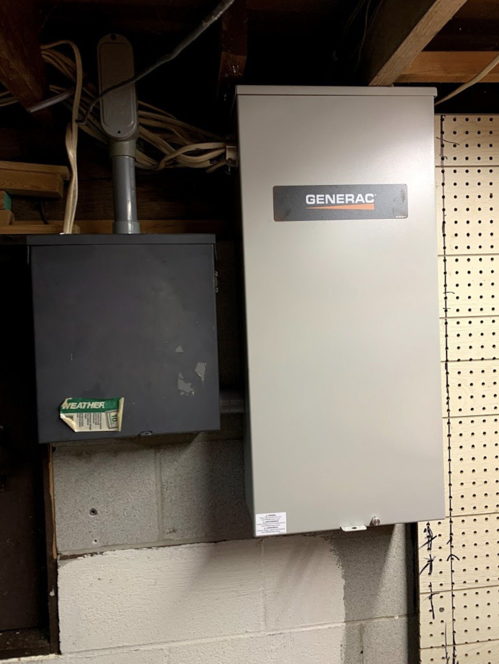 A generator is sitting on a wall next to a box.