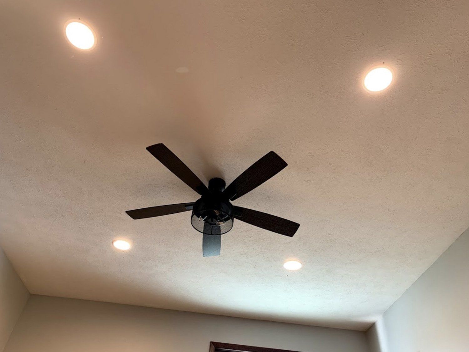A ceiling fan is hanging from the ceiling of a room