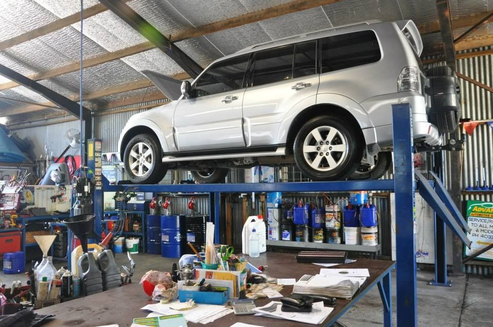 A Silver Suv Is Parked On A Lift In A Garage — Advanced Automotive Services In Earlville, QLD