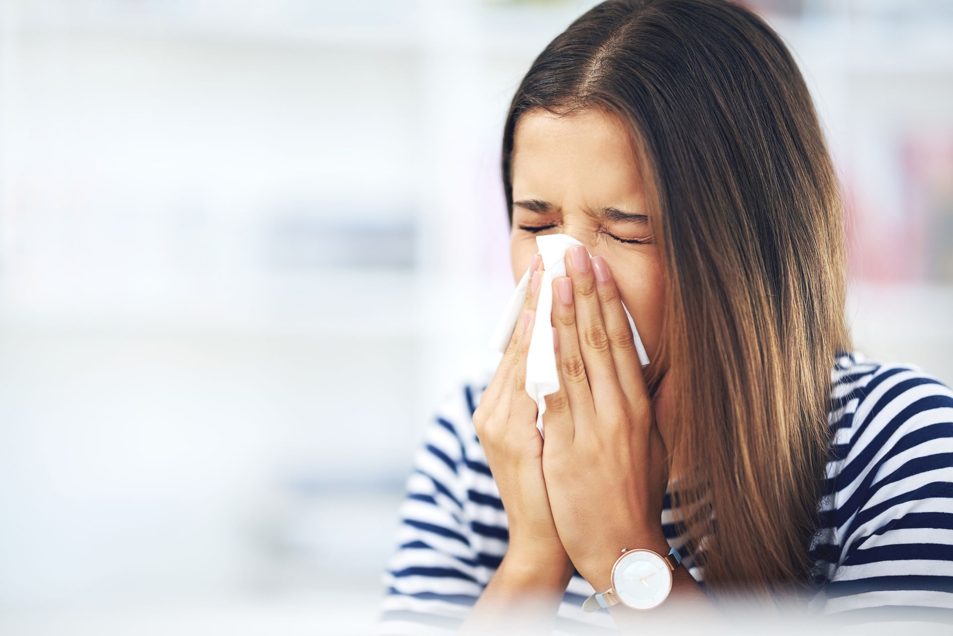 A woman is blowing her nose into a napkin.