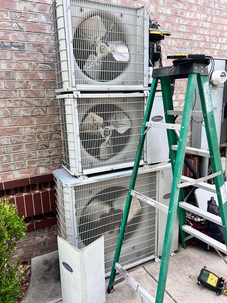 A green ladder is sitting next to a stack of air conditioners.
