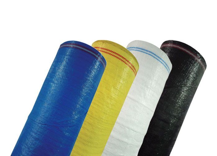 Tres rollos de tela de diferentes colores sobre un fondo blanco.